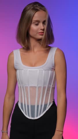 Beautiful stylish model in the studio with a bob hairstyle on a multi-colored background. Beautiful well-groomed hair. Vertical video.