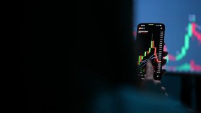 Closeup of unrecognizable female cryptocurrency trader investor holding smartphone, scrolling through screen, doing stock market data price graphs analysis, using cryptocurrency trading mobile app. - Powered by Shutterstock - Get 15% off with code: PIKWIZARD15
