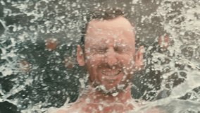 Man drenched with huge water balloon splash in extreme 4k 800fps slow motion, close up face with string light background - Powered by Shutterstock - Get 15% off with code: PIKWIZARD15