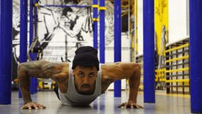 Strong sportsperson doing push ups at modern gym. Sportsman exercising at sport club. Muscular athlete showing hard and intense workout. Active sportive lifestyle concept. Slow motion - Powered by Shutterstock - Get 15% off with code: PIKWIZARD15