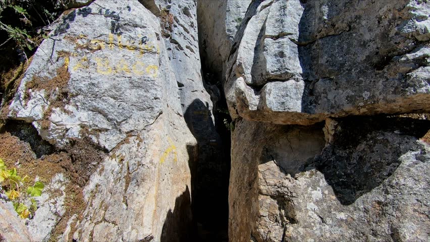 Walking through the rock corridor known as The Crack or La Grieta in natural park El Torcal of Antequera, Malaga, Andalusia, Spain. Point Of View (POV), subjective view