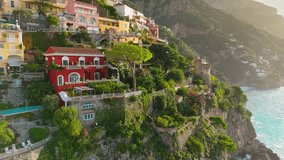 Flying above colorful houses, church and beach with turquoise water - Positano village, Italy. Famous tourist resort of the Amalfi coast - Positano. UHD, 4K - Powered by Shutterstock - Get 15% off with code: PIKWIZARD15