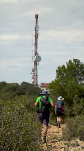 Slow motion, people from behind, walking on mountains.	