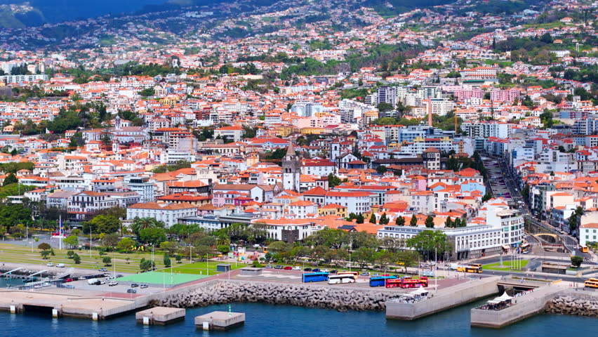 Funchal city on Madeira island on Atlantic ocean coast, Portugal island in ocean. Aerial slide shot