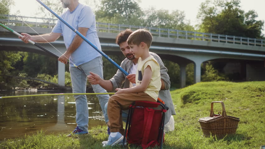 Three male family generations fishing together ona a river