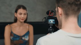 Boyfriend or cameraman with live streaming equipment filming young woman making beauty and cosmetic tutorial content. Beauty blogger make beauty care video to social media audience or follower. Adit