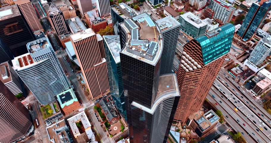 Rising over the rooftops of the highest buildings in the downtown of Seattle, Washington State, the USA. Numerous transport moves buy the highways in the city. Aerial view.