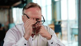 Worried adult Caucasian man takes off his glasses. Man sits holding his hand at the cheek thinking over something. Close up. - Powered by Shutterstock - Get 15% off with code: PIKWIZARD15