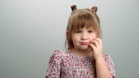 Background video of children's emotions, a portrait of a girl covering her face and smiling. The child is playing hide and seek, a happy childhood. High quality 4k footage