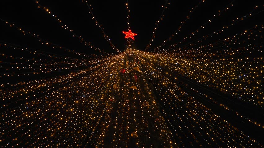 Christmas tree decorated with lights and toys. Outdoor in evening time. Nobody