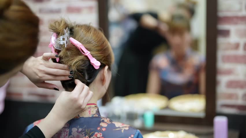 A graceful young Taiwanese woman in a vibrant cheongsam sits for styling in a quaint historic alley in Bopiliao, Wanhua District of Taipei, surrounded by traditional wares and storefronts.