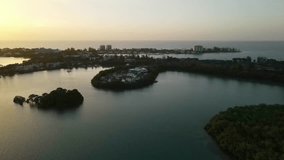 homes on the mountains alongside the beach, arial drone footage at sunset
