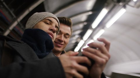 Happy young male couple take a selfie on a subway escalator  : vidéo de stock