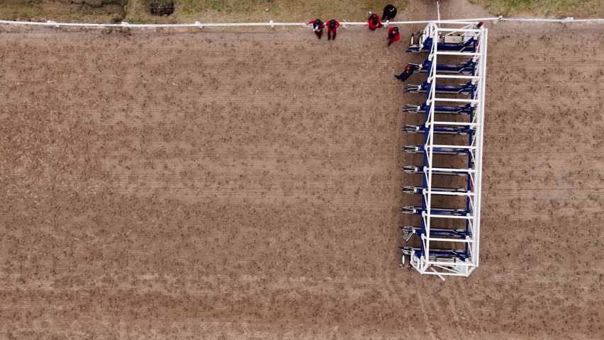 Jockeys and trainers prepare the horses for the start of a race at the Palermo Racecourse, Buenos Aires, Argentina. Top angle camera flies over the track