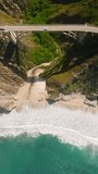 Vertical Screen: Beautiful nature of California West Coast, USA. Car driving on windy mountain coast road by scenic Bir Sur shore. 4K aerial top down view above vehicle. Road number 1 main road