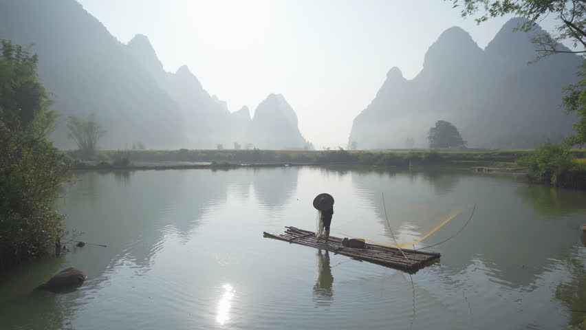 A fisherman with rice terraces, green agricultural fields in countryside or rural area of Cao Bang, mountain hills valley in Asia, Vietnam, China border. Nature landscape. People