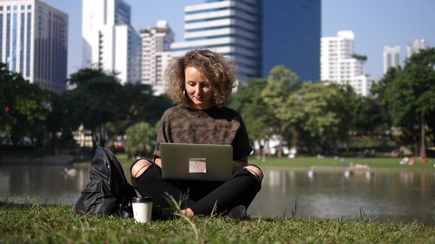 Happy Woman Working On Laptop Enjoying Sunshine In Park. 4K.
