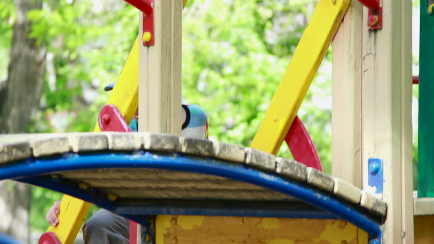 The boy climbs the ladder on the playground.