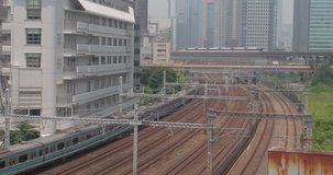 TOKYO, JAPAN – JUNE 2016 : Video shot of train moving in central Tokyo with tall buildings and car traffic in view