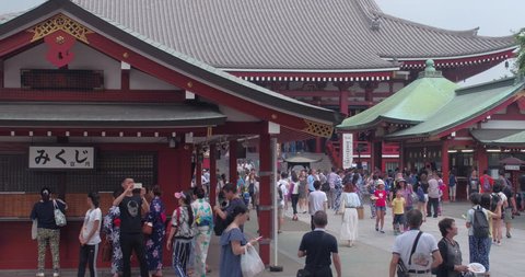 TOKYO, JAPAN – JUNE 2016 : Video shot of Asakusa street on a sunny day with people and old temple in view