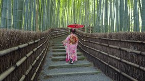 4k Slow motion video Asian woman wearing a traditional Japanese kimono at Bamboo Forest in Kyoto, Japan.