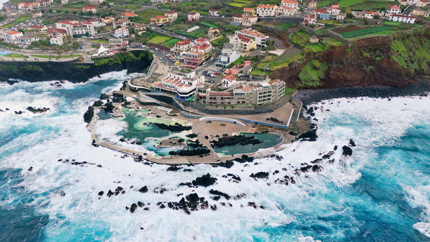 Natural lavas pools at Porto Moniz during sunlight with stormy waves Atlantic ocean in Madeira island