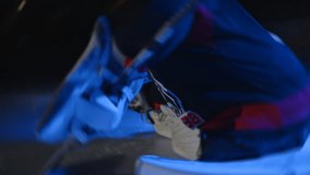 Ice hockey goaltender goalie warms up before game Workout butterfly drill exercise. Goalkeeper stretches his legs at goal. Do a split. Protective gear equipment. Blue light. Ice arena with lights off - Powered by Shutterstock - Get 15% off with code: PIKWIZARD15