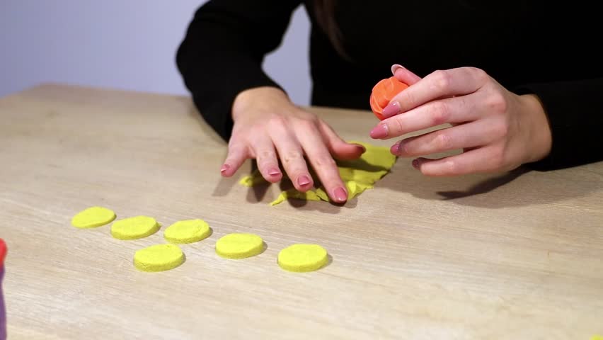 Woman plays with kinetic sand at the table.