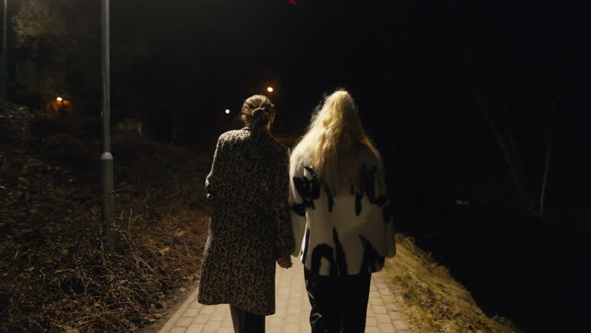 Nighttime joyride: slow motion of LGBT women in fur coats having fun