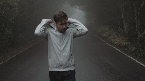 Young handsome runner in a misty forest, slow motion video Stock Video