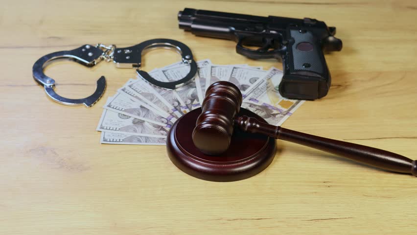 Judge Hammer for adjudication with handcuff, gun and dollars money. Auction or Lawyer decision. Law and justice concept. Court of law. Pronouncing sentence, striking Gavel.