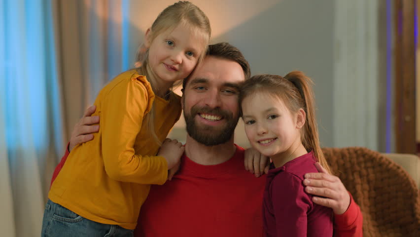 Happy family Caucasian affectionate parent man father daughters hugging bonding at home love dad little girls kids siblings cuddling embracing together smiling children custody adoption father's day