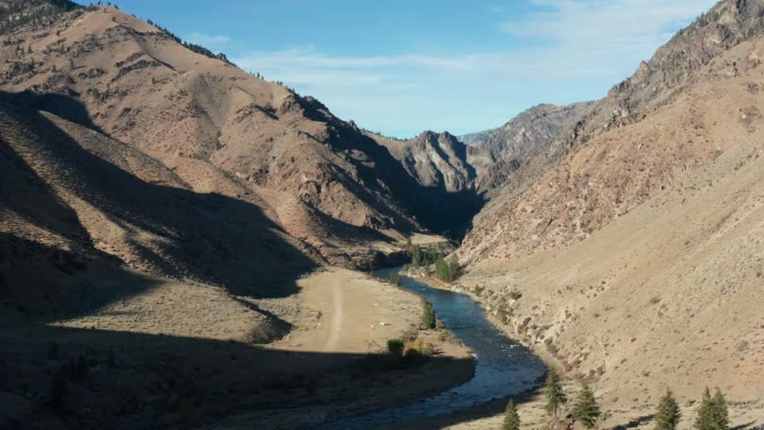 Drone footage of a remote landing strip and camp surrounded by mouintains and near a river in the Frank Church River of No Return Wilderness in Idaho