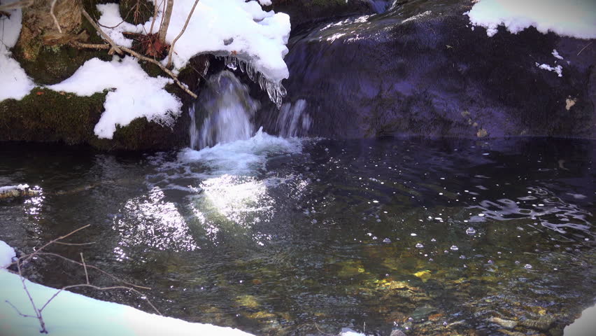 Melt water feeds a small cascade in a mountain spring.