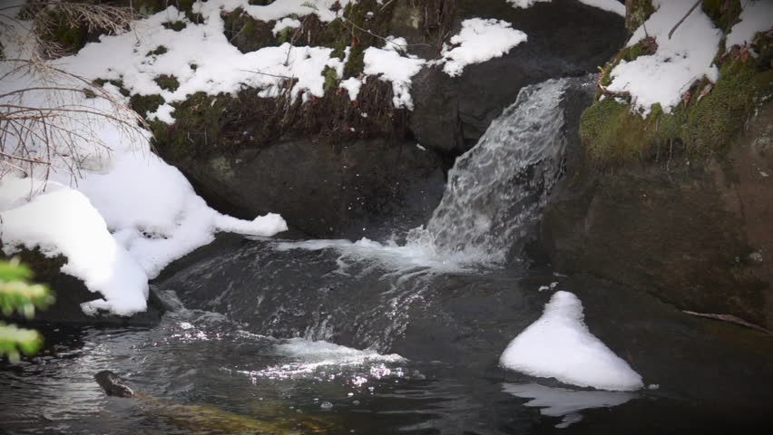 Mountain spring water cascades over rock in slow motion.