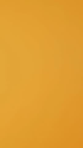 Vertical Video Confident male courier carrying big pile of pizza boxes to deliver fast food order to clients, takeaway service in studio. Young smiling deliveryman bringing takeout meal stack. Camera