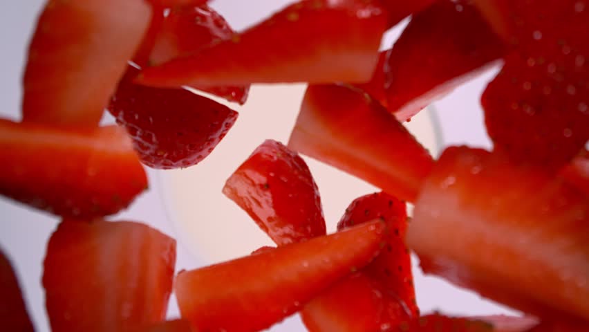 Super Slow Motion Shot of Fresh Strawberries Followed by Camera Falling into Cream at 1000fps.