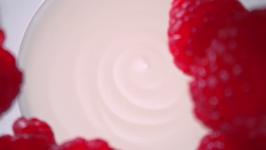 Super Slow Motion Shot of Fresh Raspberries Followed by Camera Falling into Yogurt at 1000fps.