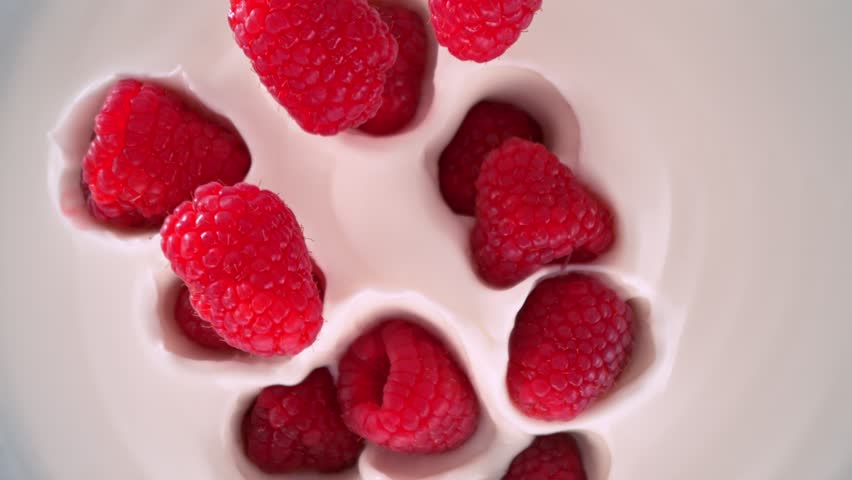 Super Slow Motion Shot of Fresh Raspberries Followed by Camera Falling into Yogurt at 1000fps.
