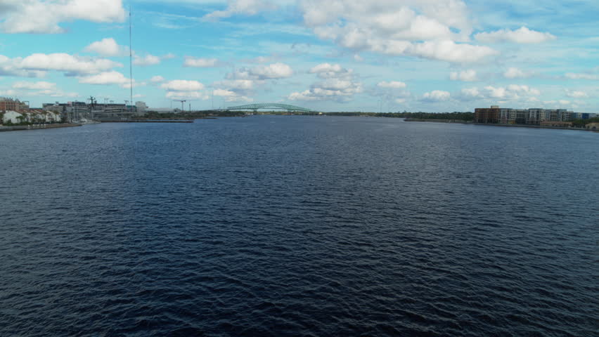 Aerial footage flying over the St. Johns River in Jacksonville Florida with the Hart Bridge in the background.
