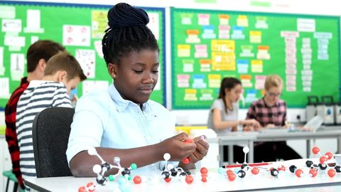 Teacher And Pupil Using Molecular Model Kit In Science Lesson, videoclip de stoc