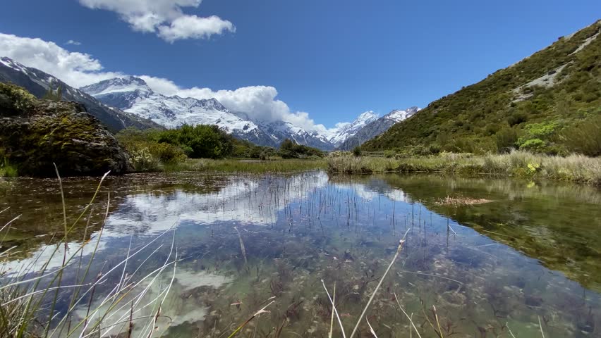 Hill top view of Aoraki Mount Cook and blue sky with clouds reflecting in water at Red Tarns, Mount Cook National Park, New Zealand 