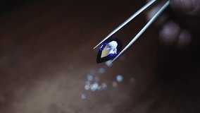 A person is holding a gemstone in a pair of tweezers - Powered by Shutterstock - Get 15% off with code: PIKWIZARD15