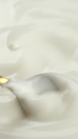 Sour cream or greek yogurt stir with spoon, close up