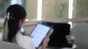 Focused woman interacting with digital tablet indoors