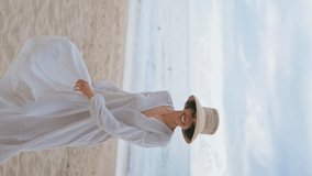 Happy traveler spinning beach on cloudy day vertical video. Carefree woman enjoying coast vacation feeling happiness freedom. Joyful girl looking camera resting rocky island shore. Outdoor leisure - Powered by Shutterstock - Get 15% off with code: PIKWIZARD15