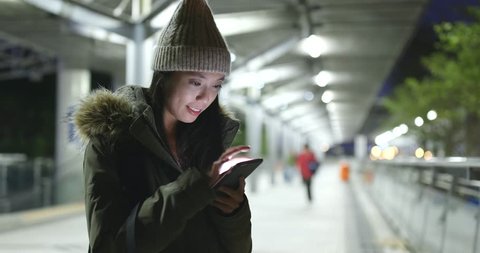 Woman wearing winter jacket and using mobile phone in the city Stock Video