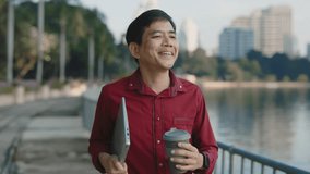 Senior Male Going Outside near the Lake with Laptop and Drinking Coffee. Elderly Asian Boss Walking Before Work with Hot Tea Carrying Computer Device. Business and People Concept - Powered by Shutterstock - Get 15% off with code: PIKWIZARD15