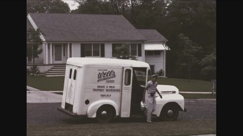 CIRCA - 1953 - A milkman delivers milk bottles to a porch and a housewife picks them up and brings them into her home.