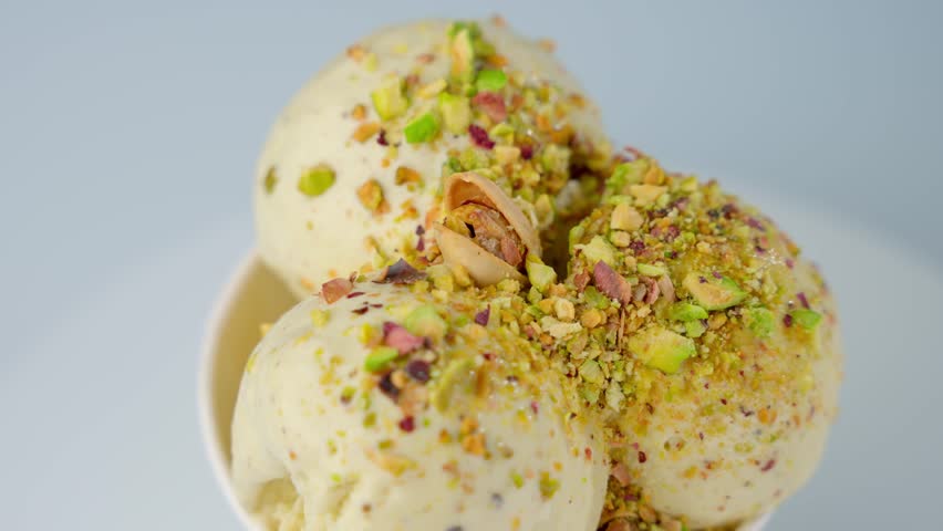 Creamy ice cream with pistachios close-up. Concept of cold desserts.